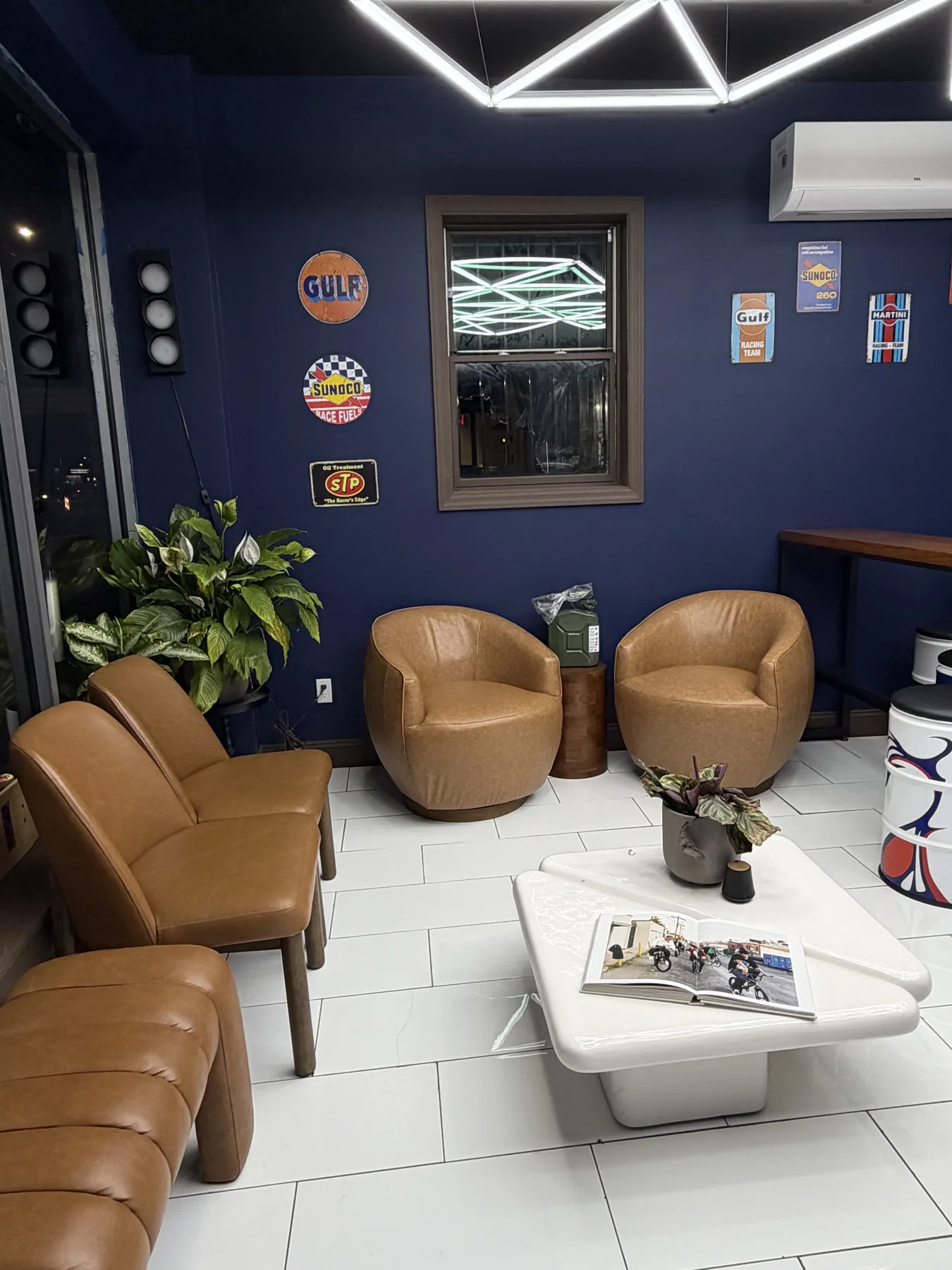 A Cuts Studio customer seating area with comfortable leather chairs and racing decor